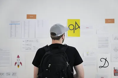 Designer looks at work variants on a large wall