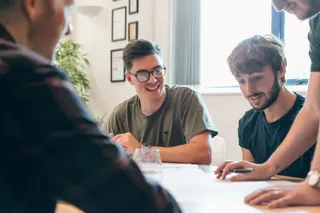 Mike smiles as Tom questions a wireframe